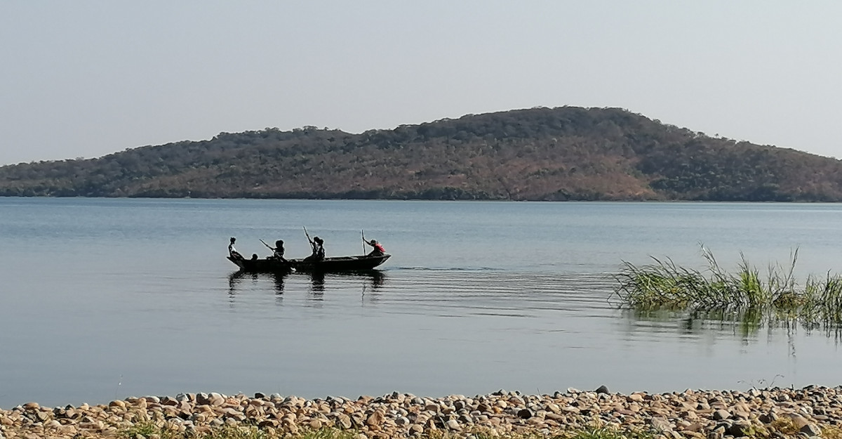 Steiniges Ufer und vorbeifahrendes Boot.
